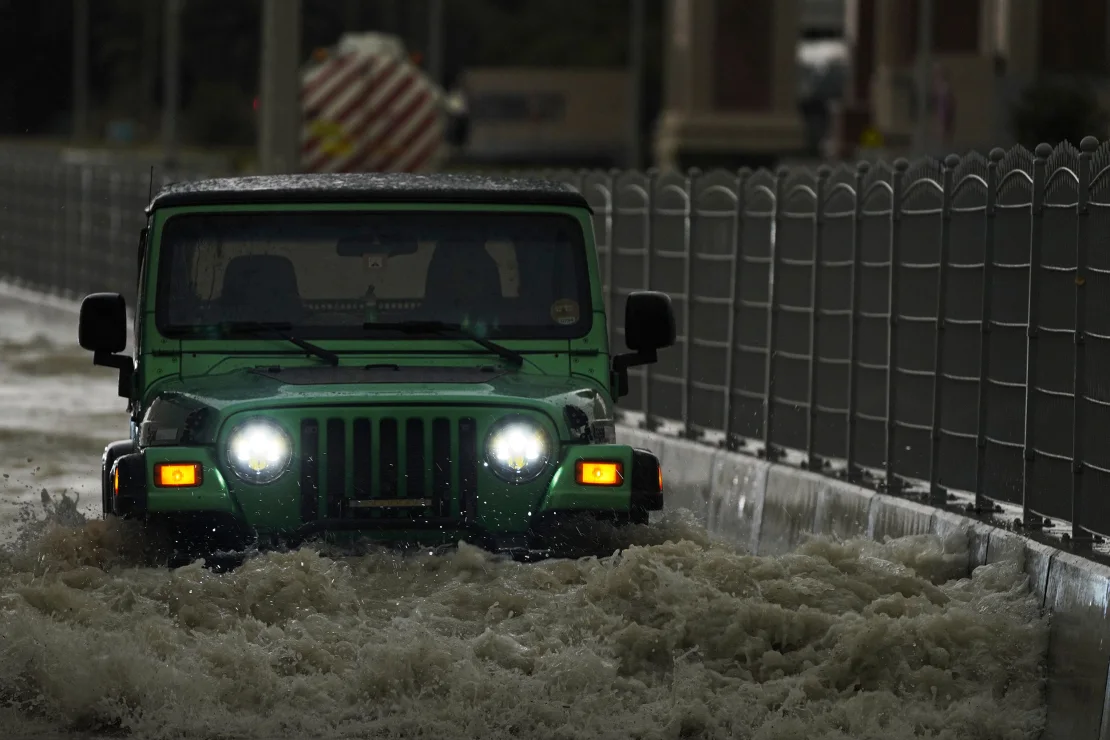 A vehicle drives through deep floodwaters in Dubai, United Arab Emirates, on April 16, 2024