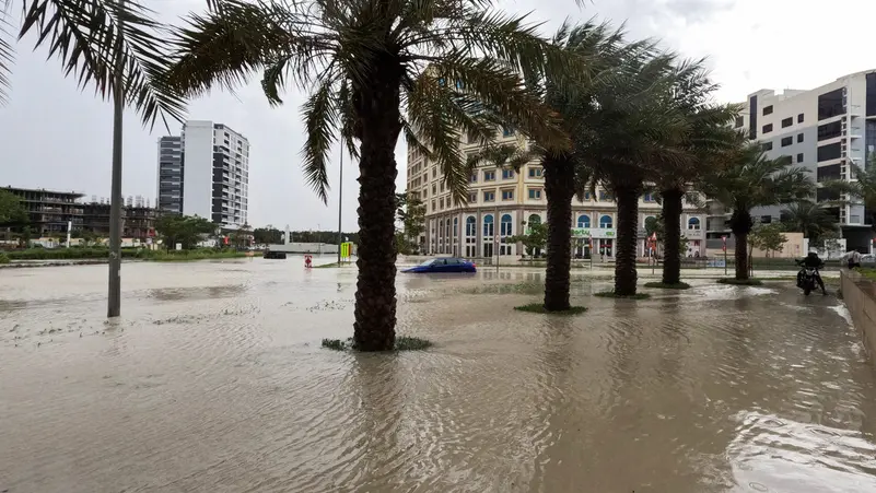 A person rides a motorcycle near a flooded street during a rain storm in Dubai, United Arab Emirates, April 16, 2024.