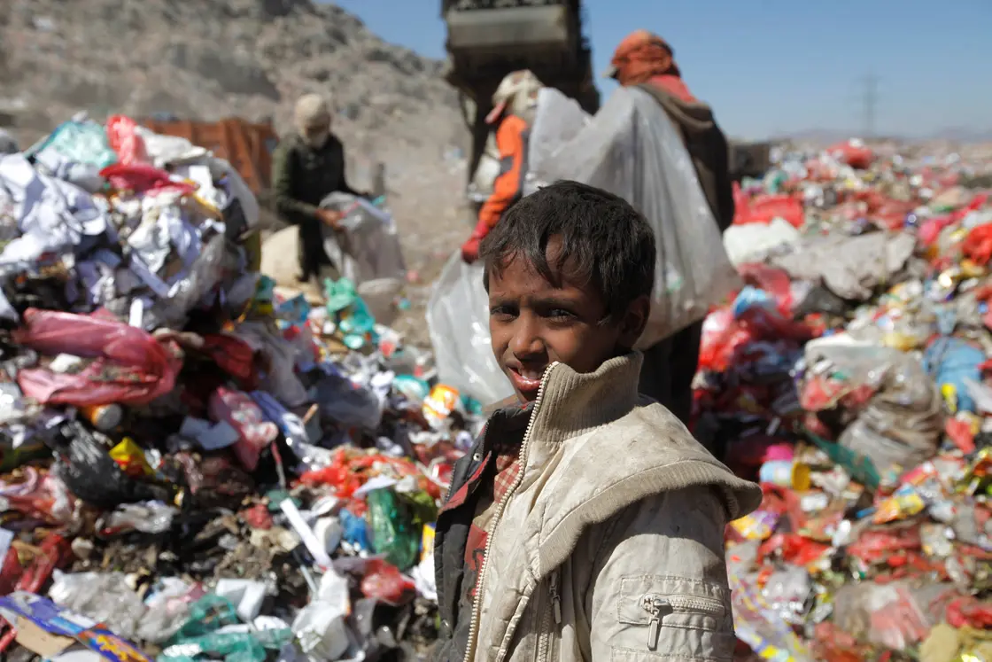 A boy and his parents dig through garbage