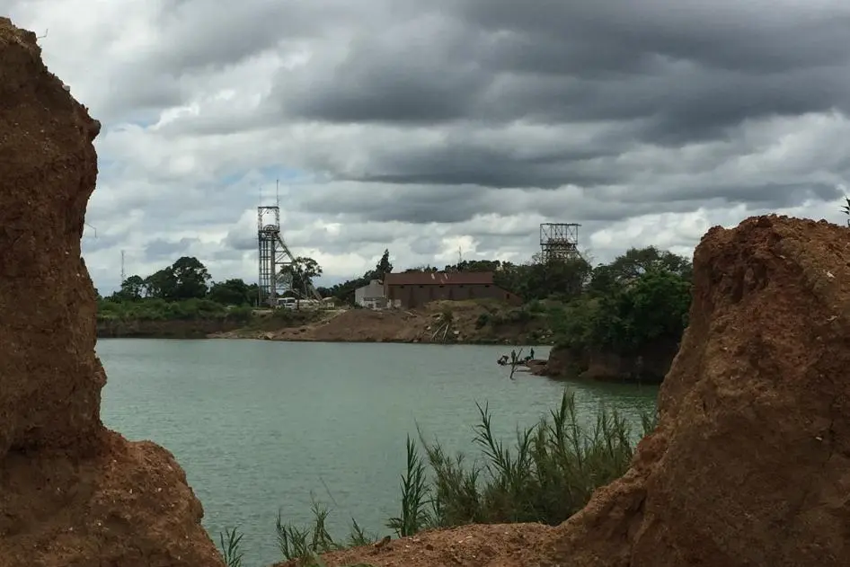 View of a former mine quarry, now flooded, at the site of an old mine in Kabwe. In the foreground is an area where small miners still work.