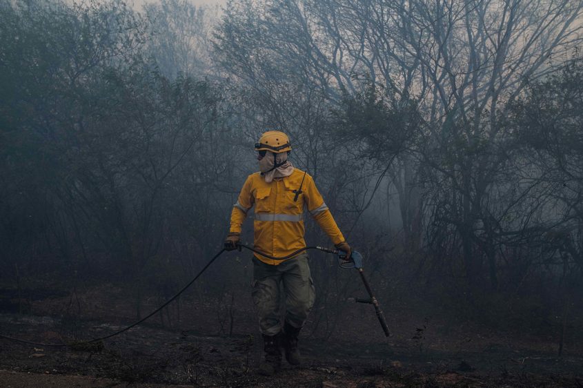 A forest firefighter works with a rapid response team to prevent a fire from advancing toward the community of Aguas Calientes in the municipality of Roboré
