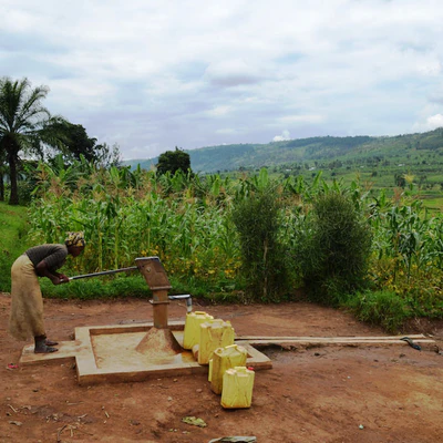 Woman pumbing water for use in Rwanda
