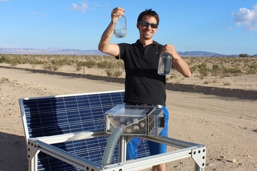 UC Berkeley postdoctoral fellow Mathieu Prévot displays water collected by the harvester (foreground) in the Mojave Desert.