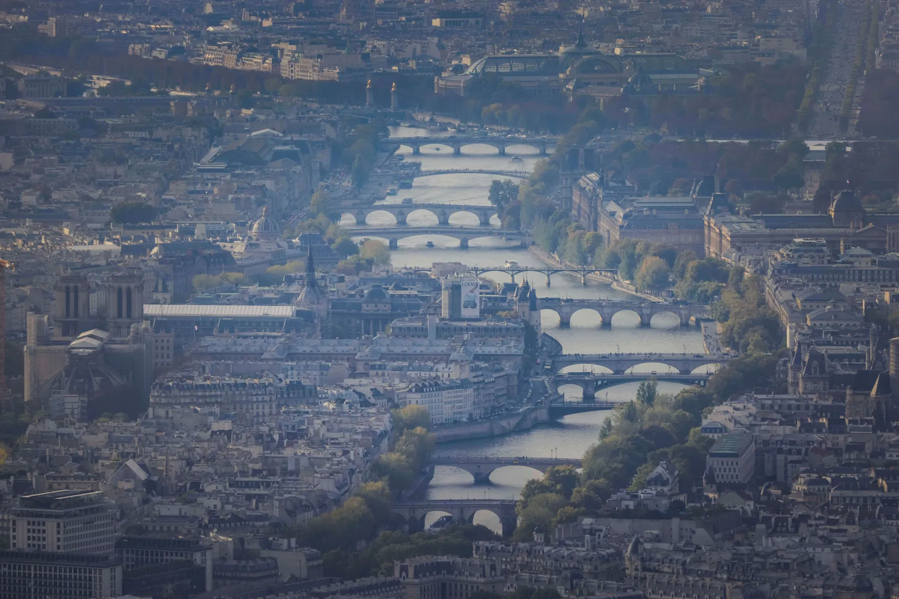 Aerial view of the Seine river winding through a smoggy Paris, France.