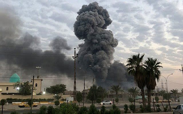 In this photo from August 12, 2019, plumes of smoke rise after an explosion at a military base southwest of Baghdad, Iraq.