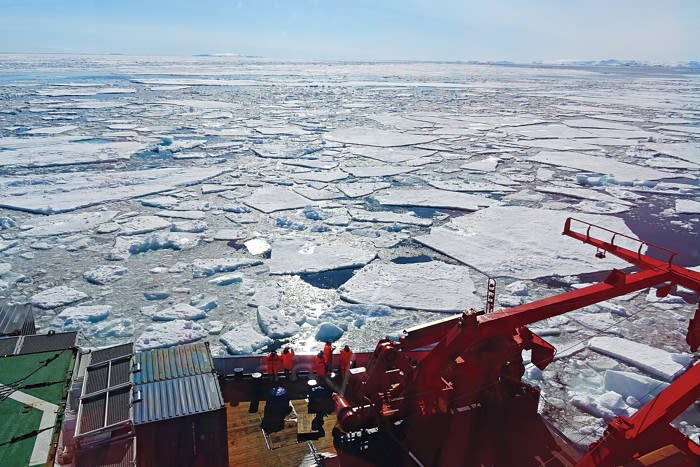 A research vessel travels through ice floes so researchers aboard can sample the environment for pollution levels.