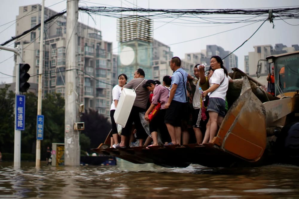 Riding on a front loader through floodwaters in Zhengzhou, Apr 19, 2024.