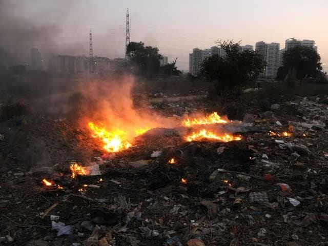 Waste burning in open area in Sector 49, Gurugram.