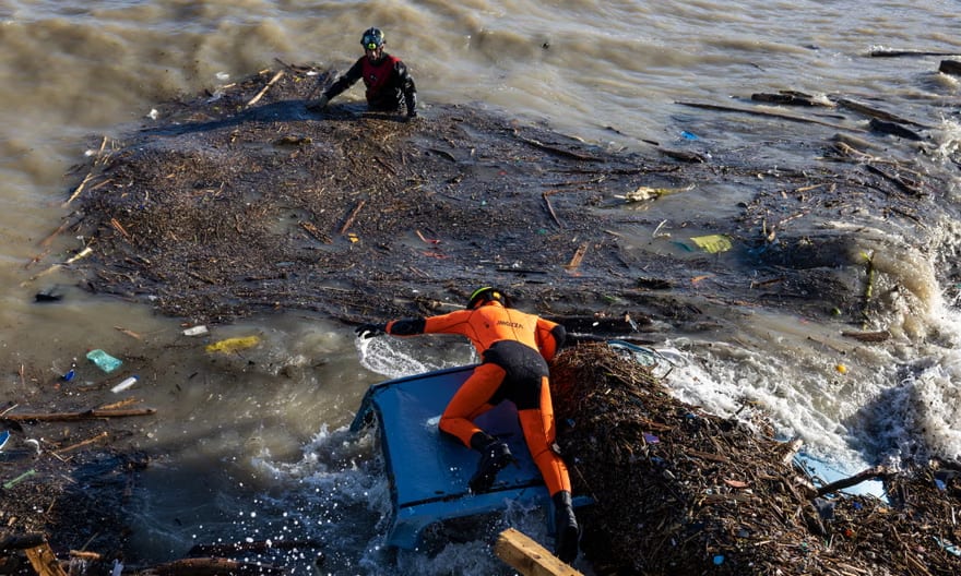 Rescuers search for survivors on the beach following the landslide on Ischia. Photograph: Roberto Salomone/The Guardian