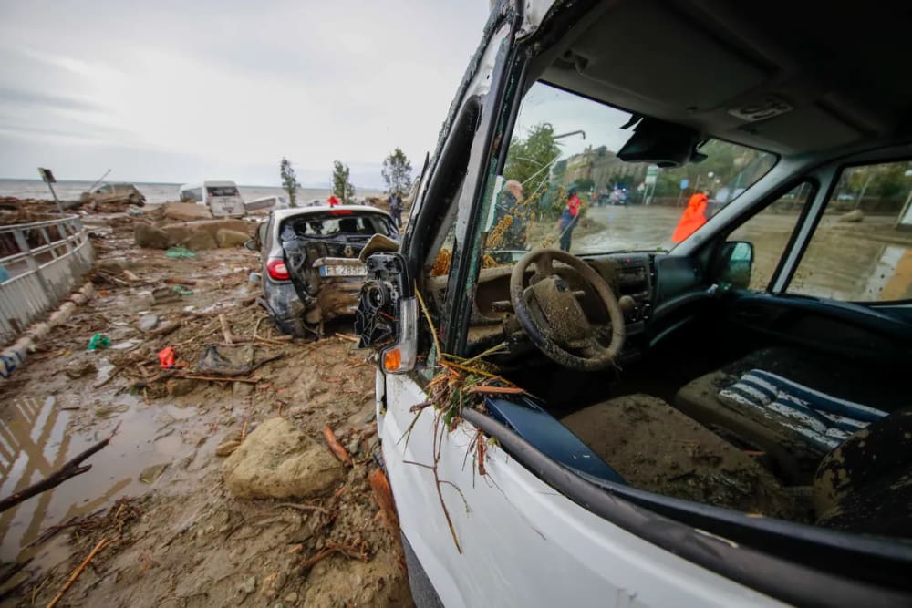 Vehicles damaged by landslides sit along the sea front at Casamicciola Terme on the island of Ischia. [Salvatore Laporta/AP Photo]