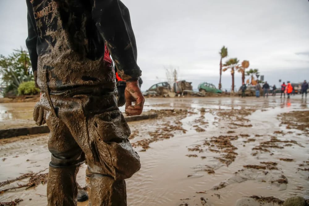 Rescuers work to remove mud along the sea front on the island of Ischia after heavy rains caused landslides. [Salvatore Laporta/AP Photo]