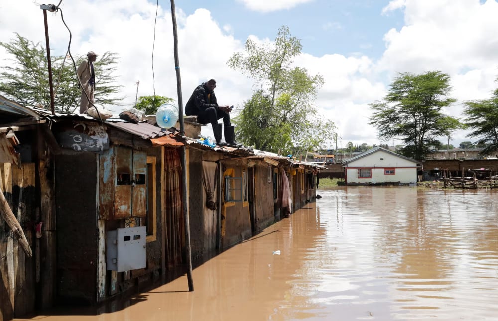 Residents rest on top of their houses waiting for rescue assistance after Athi River burst its banks and marooned their homes following heavy rainfall in Kwa Mang'eli settlement of Machakos county near Nairobi, Kenya April 24