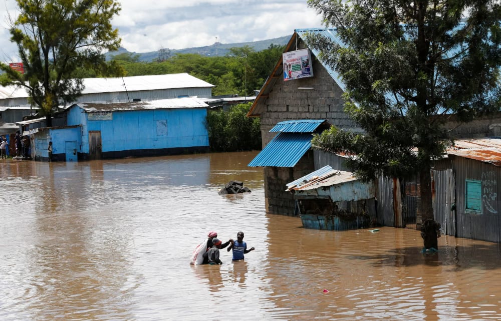 Residents wade through flash flood waters after Athi River burst its banks following heavy rainfall in Kwa Mang'eli settlement of Machakos county near Nairobi, Kenya April 24.