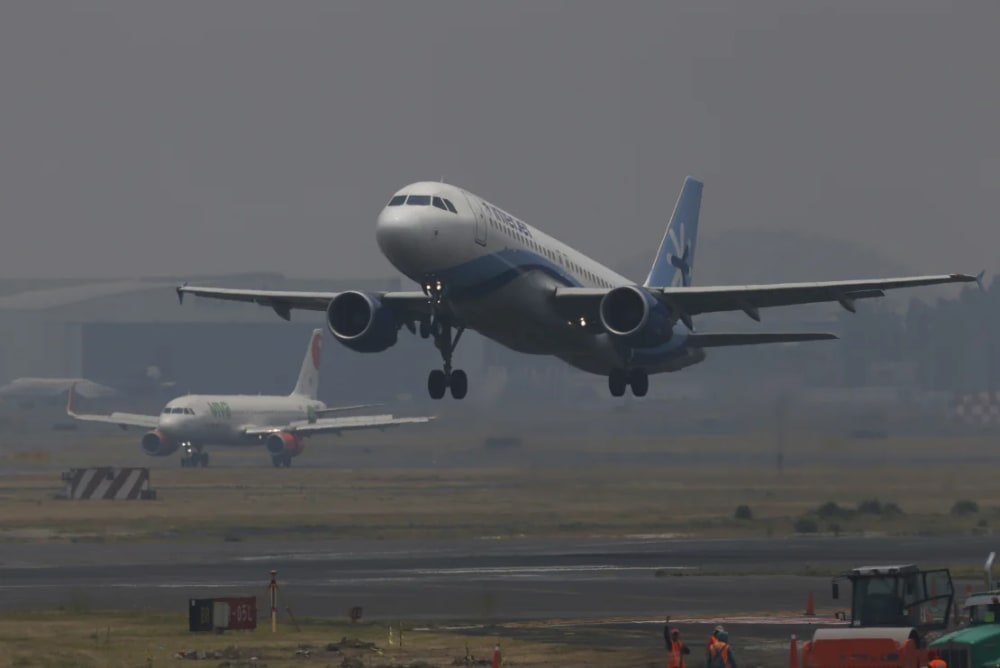 Jetliners take off from the Benito Juarez International Airport as smoke and pollution hangs Mexico City, Thursday, May 16, 2019.