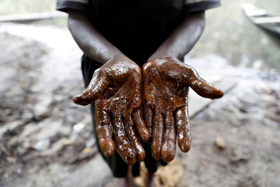 Afieyegha Seiyefa, a fisherwoman shows her hands stained by oil, following an oil spill at Santa Barbara in Nembe, in Bayelsa, Nigeria, November 25, 2021.