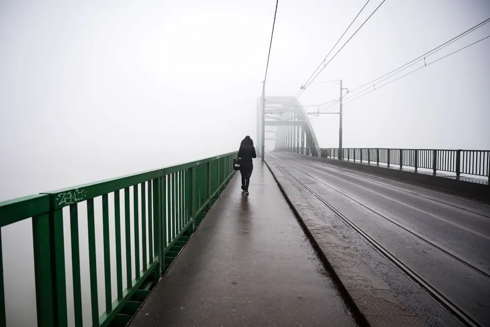 A pedestrian walks over a bridge in Belgrade as heavy fog and air pollution dominate the sky over the Serbian capital Belgrade on Jan. 16, 2020.