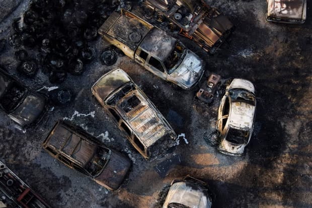Burnt-out cars sit in an auto repair shop after the building burned down in the Smokehouse Creek Fire in Canada, Texas, on February 28, 2024.