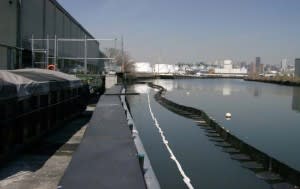 Containment boom located creekside of Peerless Importers