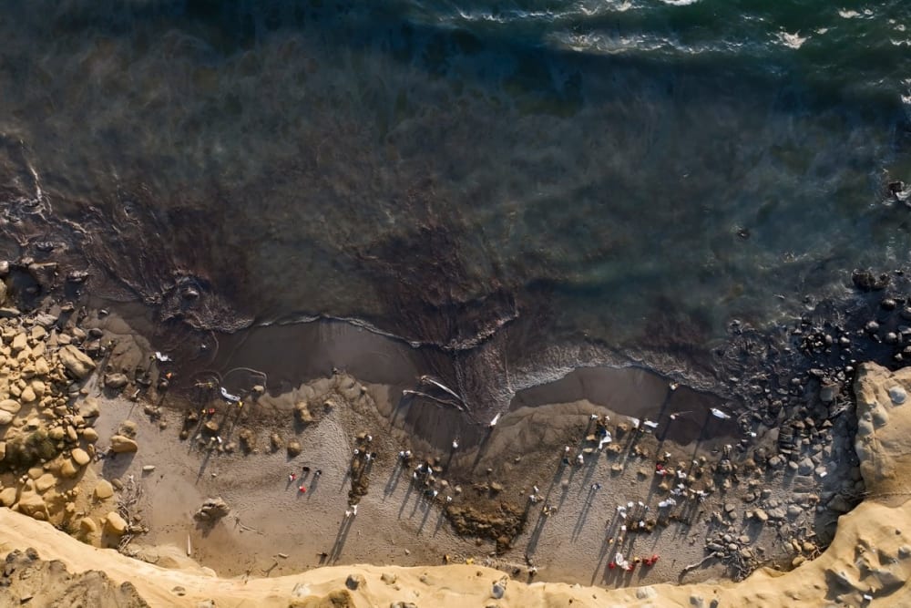Aerial view of workers cleaning up Las Capullanas beach, after an oil spill in the Lobitos district in Piura, northern Peru on December 22, 2024