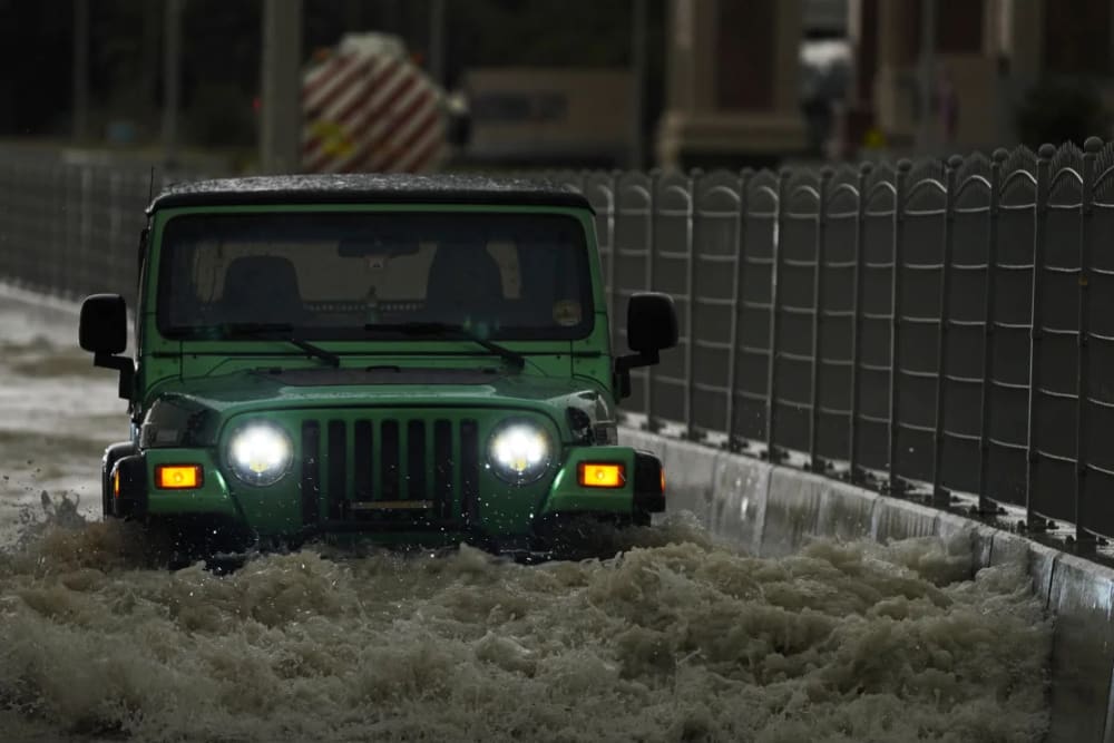 A vehicle drives through deep floodwaters in Dubai, United Arab Emirates, on April 16, 2024