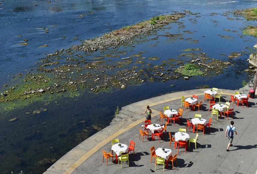 A view of restaurant tables by the Po River's drought-affected shallows, in Turin, Italy, on July 15, 2022. REUTERS/Massimo Pinca