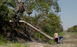 Farmers attempt to install water pumps to draw water from canals into their farms. Some wait weeks at a time for water to be released from the dam into the canal.