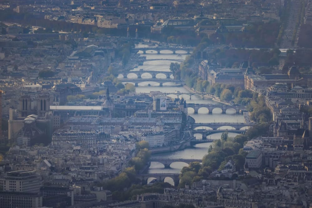 Aerial view of the Seine river winding through a smoggy Paris, France.