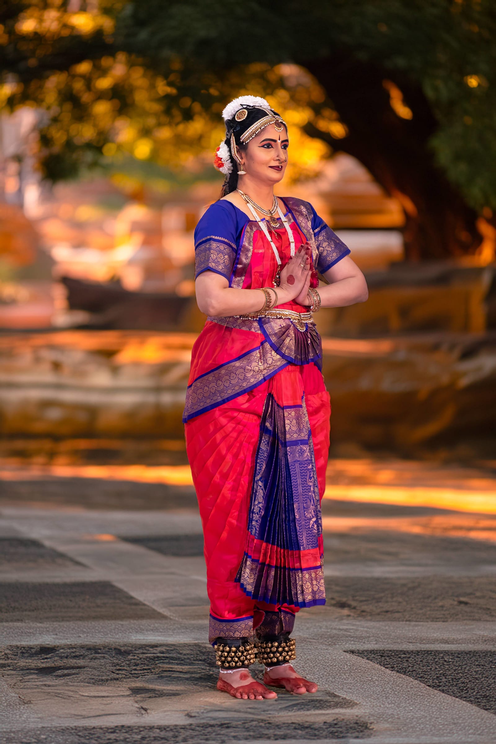 Classical Indian dancer in traditional costume under golden tree lighting