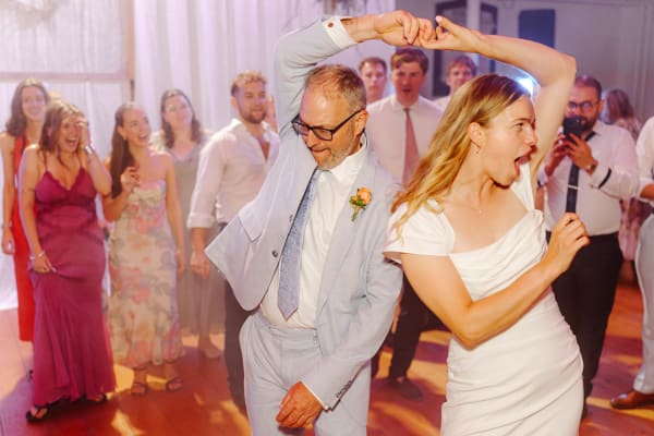 Bride dancing joyfully with a guest on the dance floor