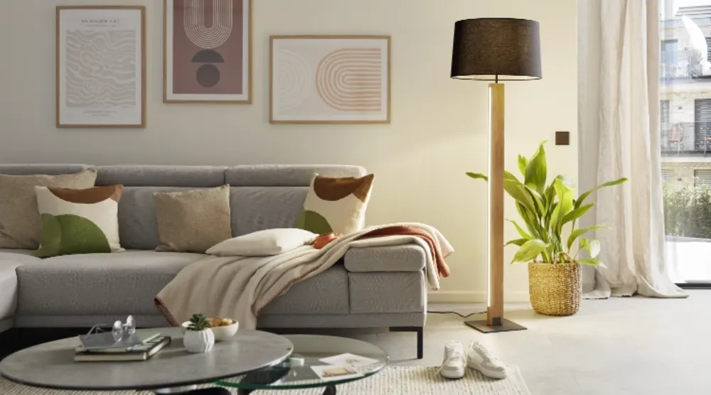 Stehleuchte mit Stoffschirm Stehleuchte mit dunklem Stoffschirm neben grauem Sofa und Holztisch in gemütlichem Wohnzimmer