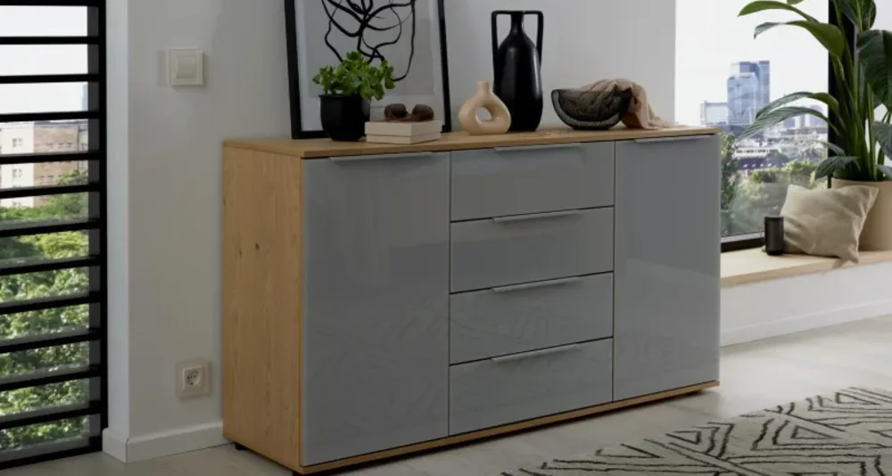 Kommode Modernes Sideboard mit grauen Hochglanzfronten, Holzrahmen und dekorativer Ablage mit Vasen und Bildern.
