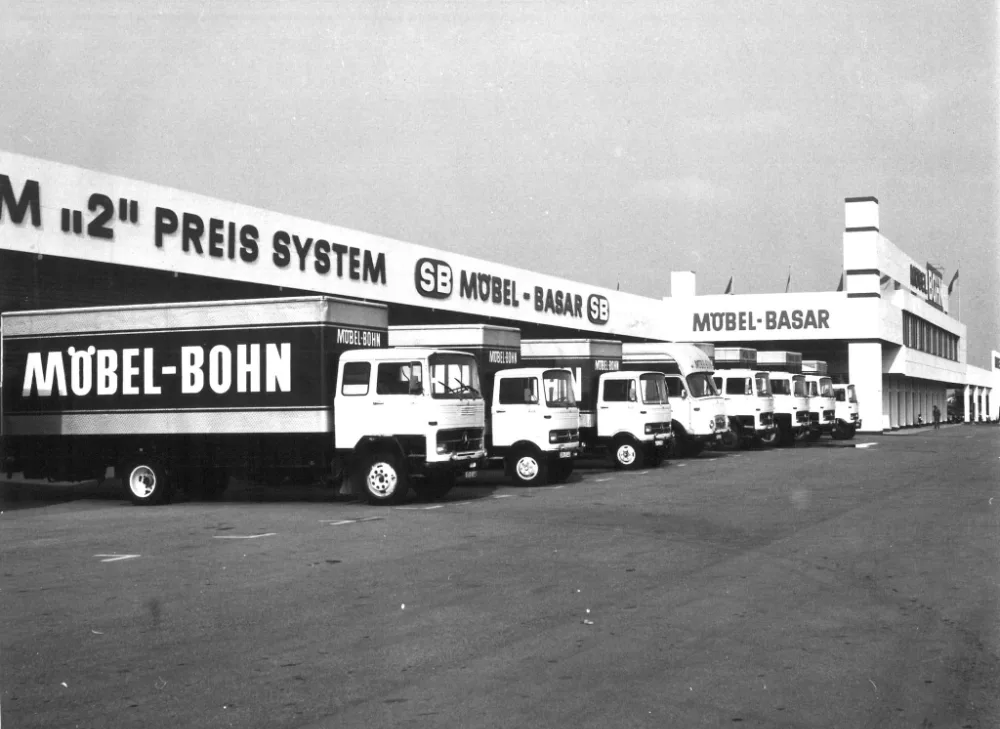 Möbel-Bohn-LKWs vor Möbel-Basar. Reihe alter Möbel-Bohn-Lieferwagen vor dem früheren SB Möbel-Basar.
