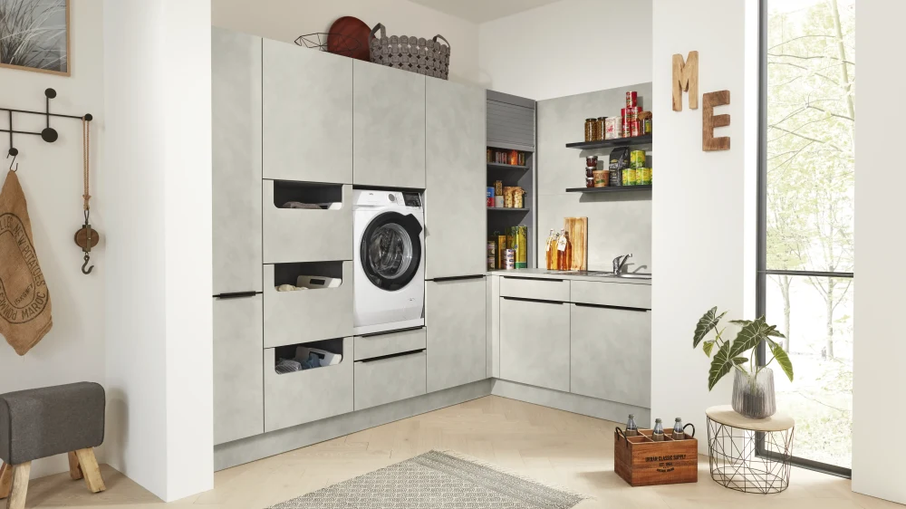 Stilvoller Hauswirtschaftsraum mit Waschmaschinenlösung Weiß-grauer Hauswirtschaftsraum mit Waschmaschine, Trockner und offenen Regalen in wohnlicher Umgebung
