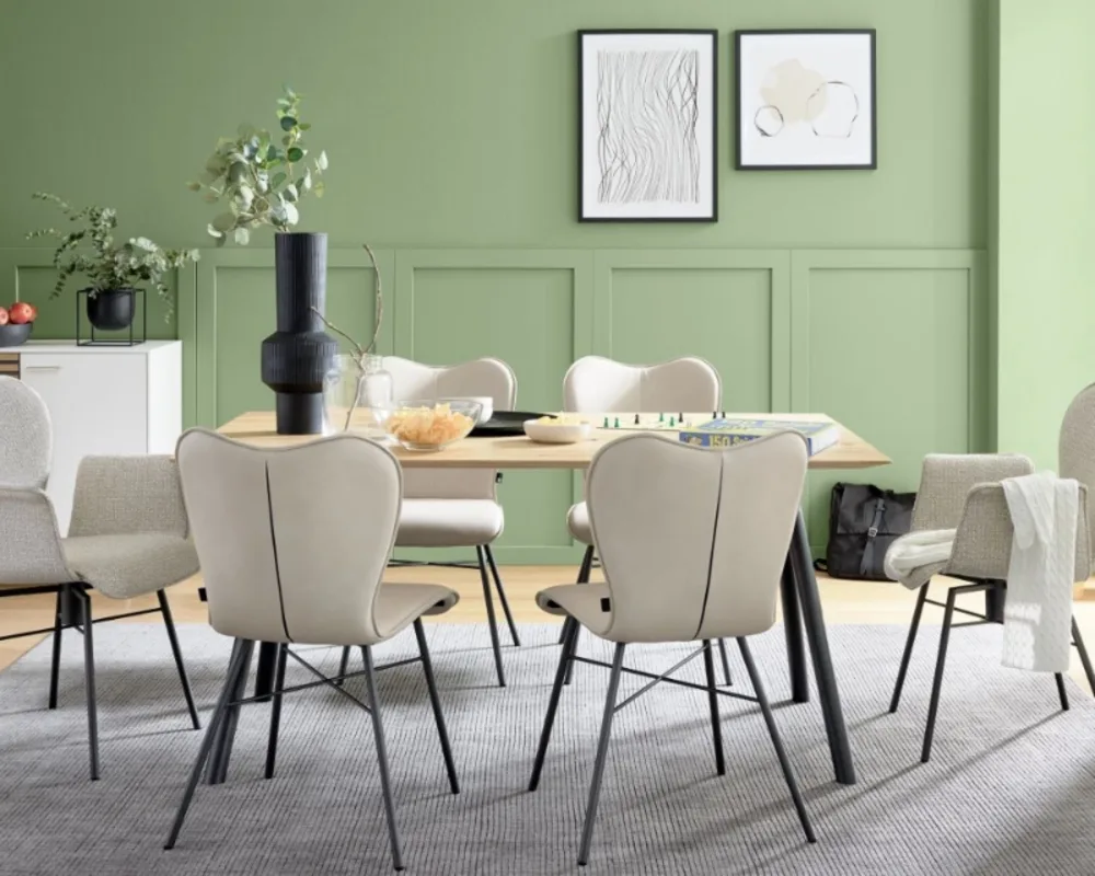 Elegantes Esszimmer mit Naturtönen, gemütlichen Polsterstühlen und stilvoller Wandgestaltung in Grün. Esszimmer mit hellem Holztisch, gepolsterten Stühlen und grüner Wand im modernen Look mit Wanddeko und Pflanzen