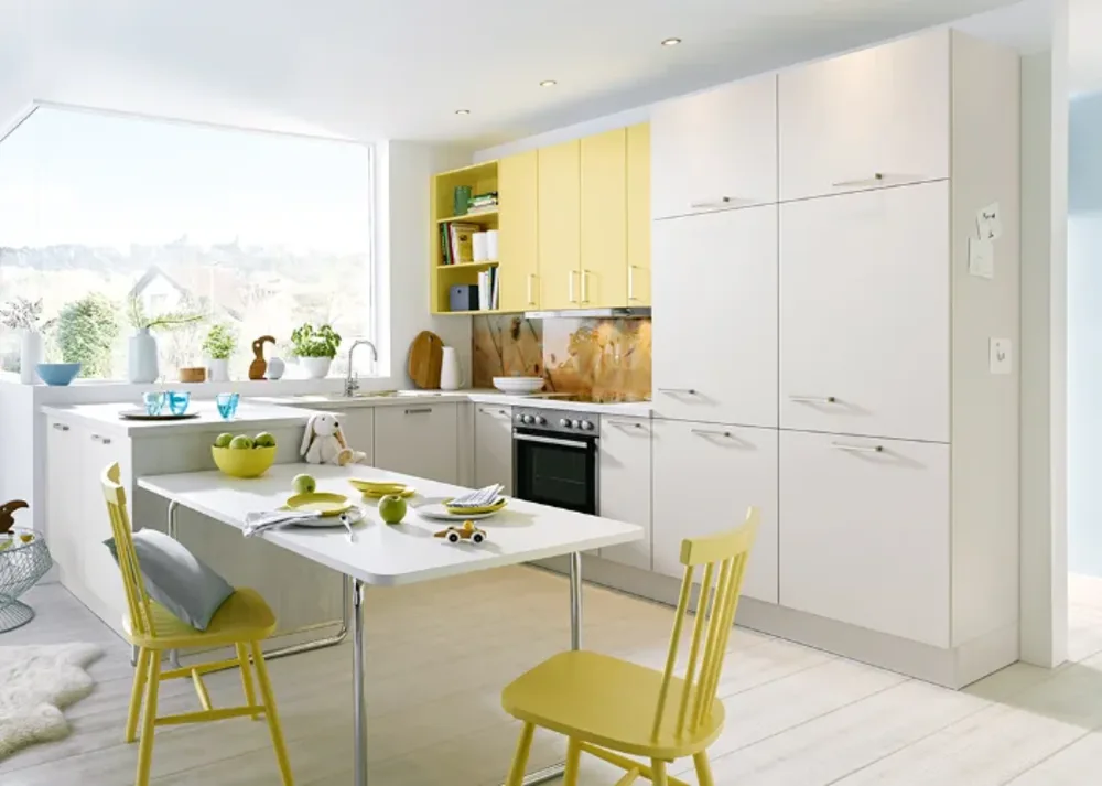Einbauküche gelb Moderne Einbauküche mit gelben Hängeschränken, Essplatz, großem Fenster, Einbaugeräten und heller Holzoptik.