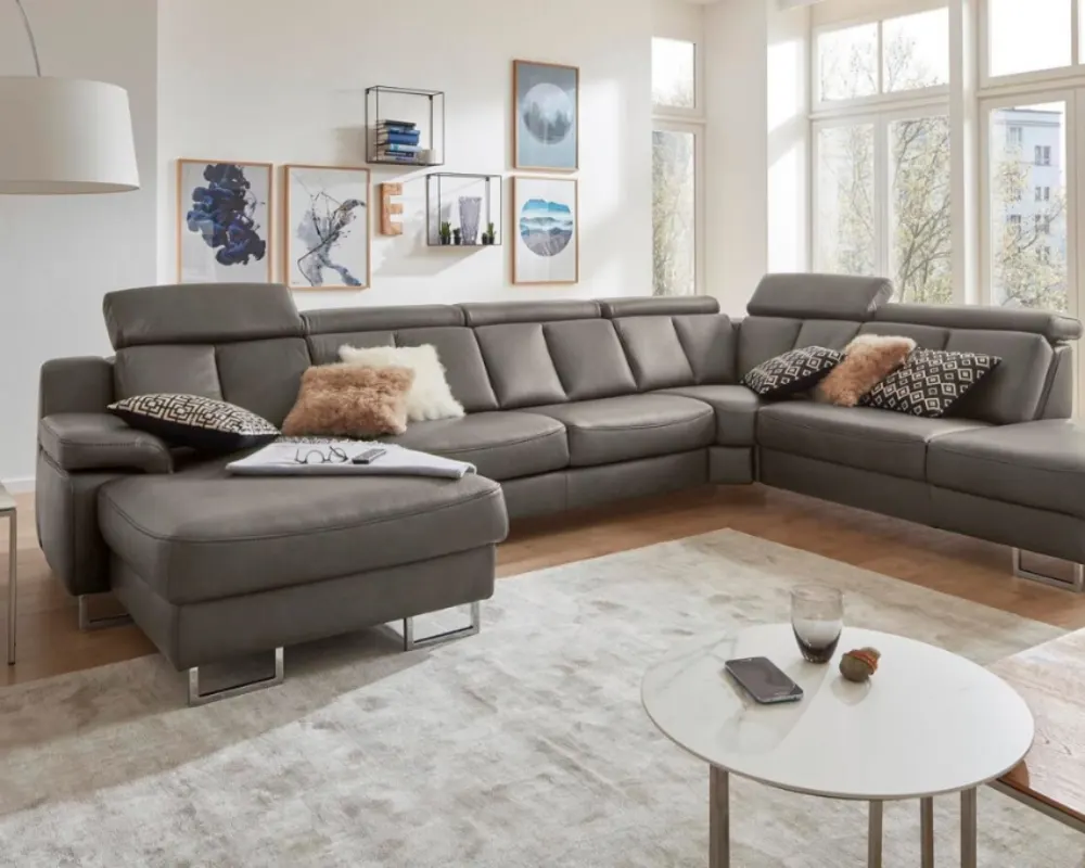 Interliving Wohnlandschaft in L-Form Großzügiges graues Ecksofa mit Kissen und Couchtisch in modernem Wohnzimmer