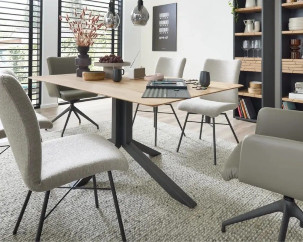 Moderne Essgruppe im Industrial-Stil mit Holzdetails, gemütlichen Stühlen und luftiger Regalwand. Essgruppe mit Holztisch, gepolsterten Stühlen und Regalwand in modernem Industrial-Stil mit offenen Lamellenfenstern
