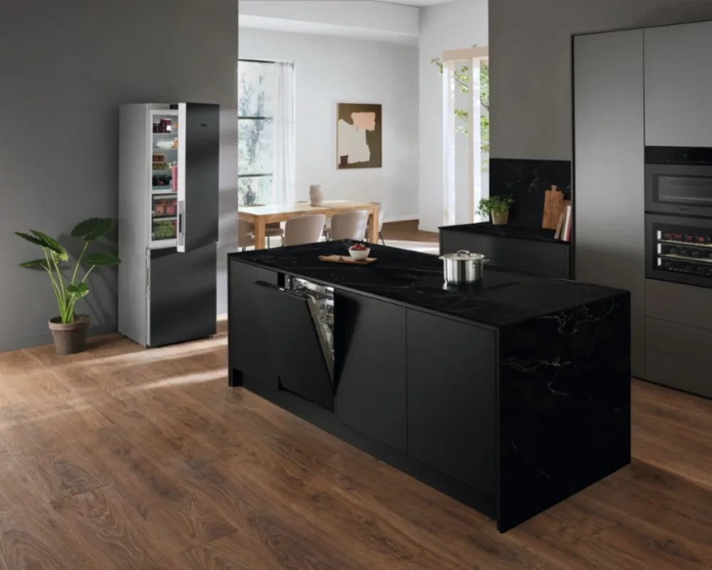 Miele Designküche in Schwarz mit Kochinsel Offene Küche mit schwarzer Miele-Kochinsel, integriertem Kochfeld und modernem Holzfußboden