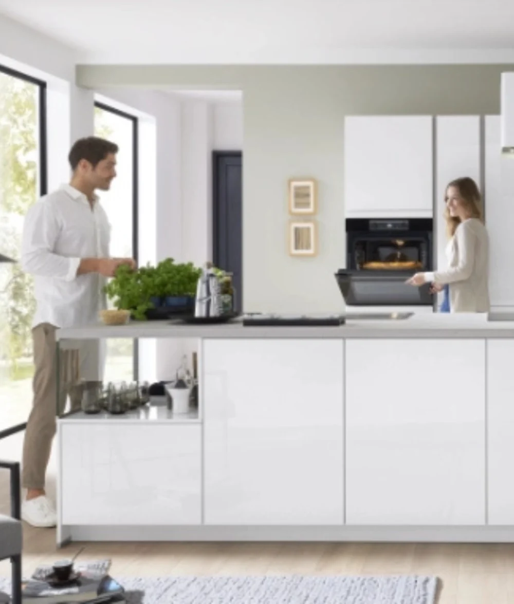 Gestelltes Küchenbild mit hellem Design Weiß-graue Küche mit integrierten Geräten, Deko und offener Atmosphäre