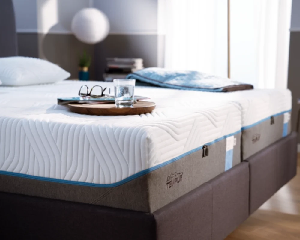 Tempur Matratze mit modernem Boxspringbett Hochwertige Tempur Matratze auf einem Boxspringbett mit Tablett und Buch auf weiß grauer Matratze