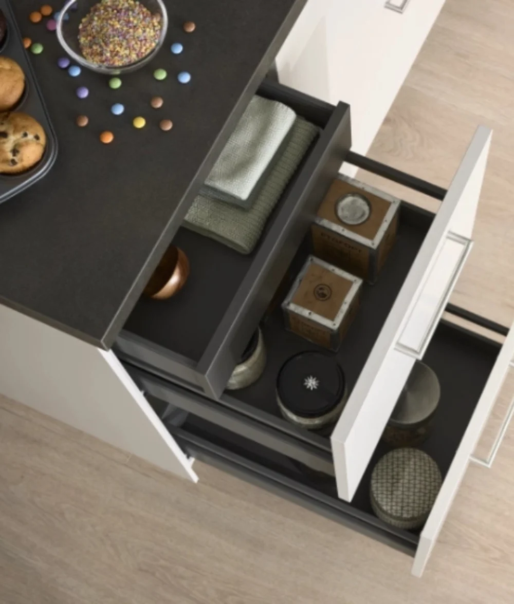 Küchenschublade mit Muffins und Backutensilien Geöffnete Schublade mit Muffins, Backblech und Küchenzubehör