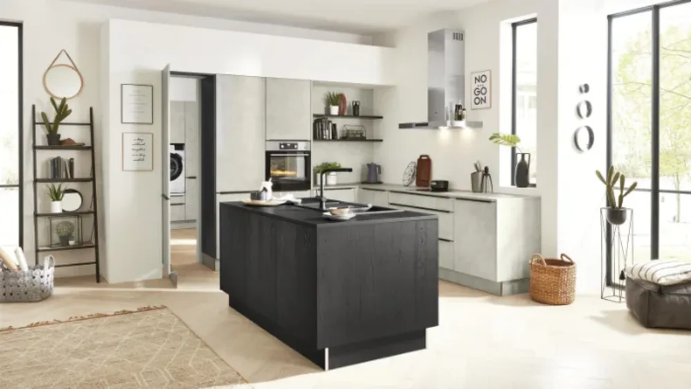 Moderne Küche mit Betonoptik Moderne Küche mit Betonoptik und schwarzer Kochinsel, viel Tageslicht, offenen Regalen und stilvoller Deko.