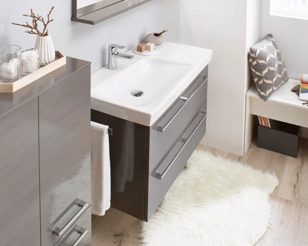 Kompakter Waschtisch in modernem Gäste-WC Kleiner Waschplatz mit grauem Unterschrank und weißem Waschbecken, ideal für kleine Bäder