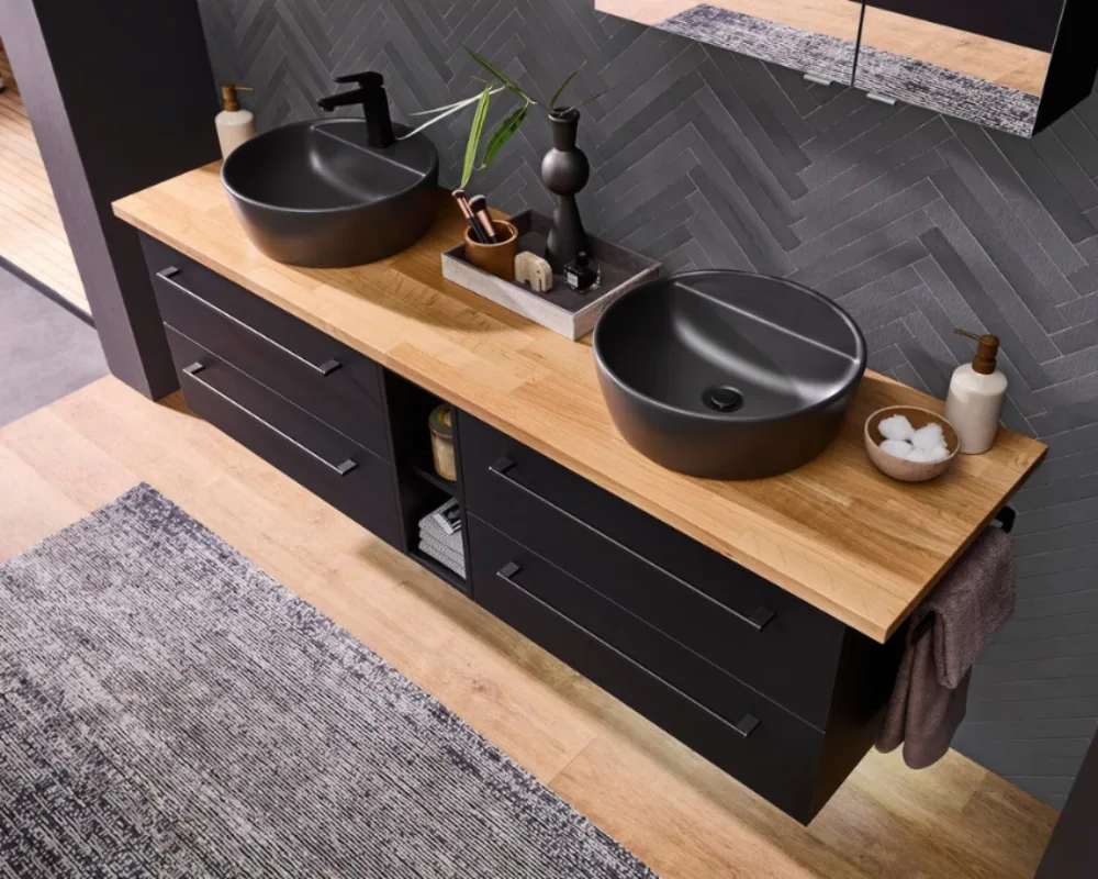 Stilvoller Doppelwaschtisch in dunkler Holzoptik Pelipal Doppelwaschplatz mit schwarzen Fronten, runden Waschbecken und heller Holzplatte