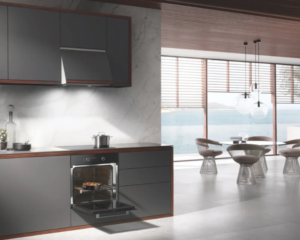 Miele Komplettküche mit integriertem Dampfgarer Offene Küche in dunkler Optik mit Dampfgarer und Dunstabzugshaube in modernem Wohnambiente