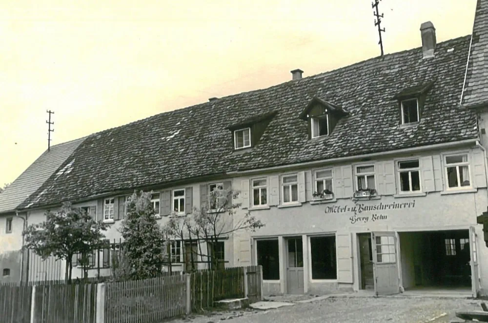 Möbelschreinerei Georg Bohn in den Anfängen. Historisches Gebäude mit Schriftzug „Möbel- und Bauschreinerei Georg Bohn“.