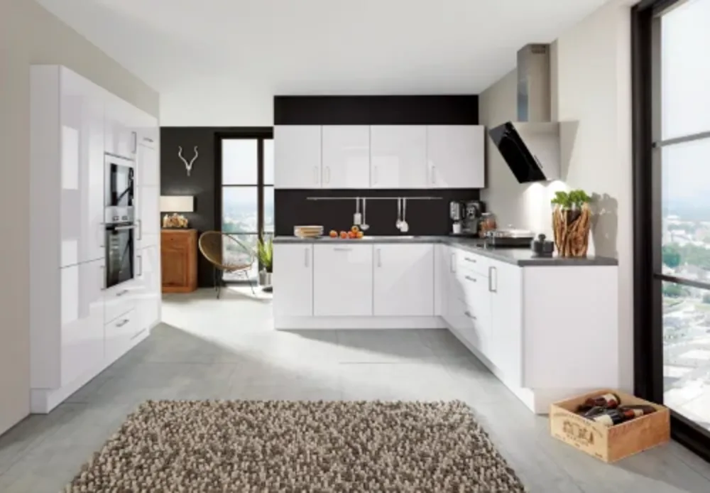 Weiße Hochglanzküche Weiße Hochglanzküche in U-Form mit schwarzer Arbeitsplatte, integriertem Backofen und großer Fensterfront mit Stadtblick.