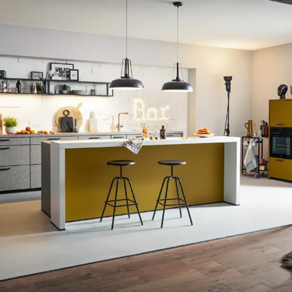 Moderne Kche gelb Stylische Wohnküche mit gelber Kücheninsel, zwei schwarzen Barhockern, Hängelampen, Wanddeko mit leuchtendem „Bar“-Schriftzug, modernen Einbaugeräten und offener Regalgestaltung.