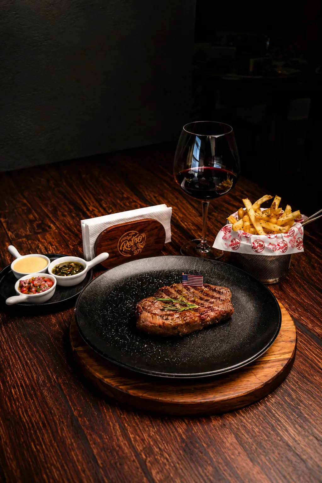Mesa servida con parrilla y copa de vino en el salón principal