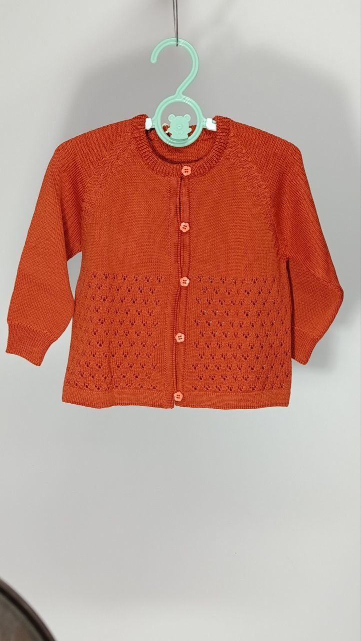 Cardigan in lana merinos per bimba, lavorato a punto punzonato che crea un effetto texture delicato sulla superficie. La lana merinos è morbidissima sulla pelle sensibile e garantisce calore senza appesantire. Taglia 9-12 mesi. €30,00.